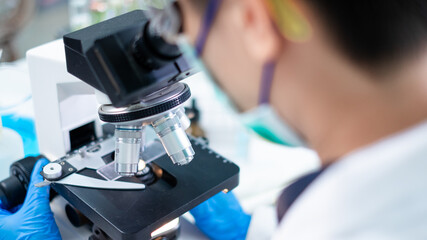 Close up of scientist using microscope and scientific equipment in a research laboratory. Concept of biology, dna, data, exam, medical or chemical study, analysis and experiment. Use of biotechnology