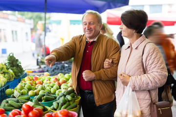 Man and a woman pick fresh organic vegetables