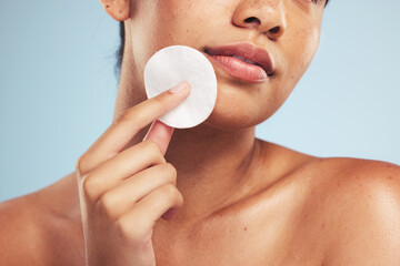 Woman, cotton pad and closeup of face for cosmetics, aesthetic glow and grooming on studio...