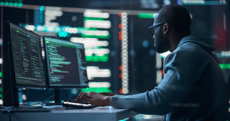 Black Male Programmer Working in Monitoring Room, Surrounded by Big Screens Displaying Lines of Programming Language Code. Portrait of Man Creating a Software. Abstract Futuristic Coding Concept