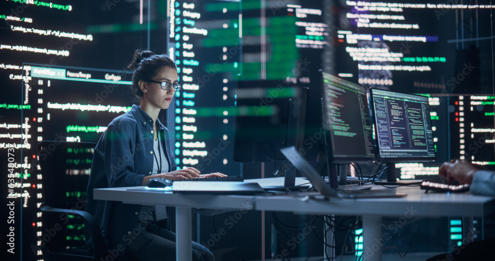 Fototapete Portrait of a Woman Working on a Computer, Typing Lines of Code that Appear on Big Screens Surrounding her in a Monitoring Room. Female Programmer Creating Innovative Software Using AI Data and System