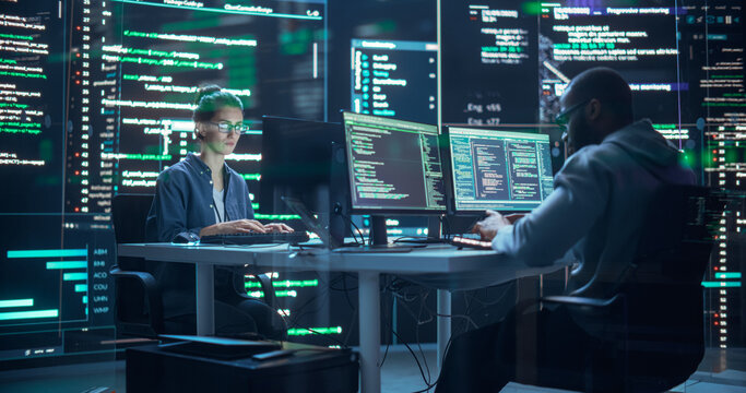Portrait of Two Diverse Developers Working on Computer, Typing Lines of Code that Appear on Big Screens Surrounding Them. Male and Female Programmers Creating Innovative Software Together, Fixing Bugs - Powered by Adobe