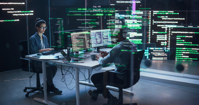 Portrait Two Diverse Developpers Working on Computers, Typing Lines of Code that Appear on Big Screens Surrounding Them. Male and Female Programmers Creating Innovative Software, Fixing Bugs - Powered by Adobe