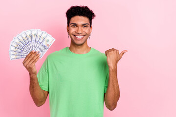 Photo of charming attractive guy wear green t-shirt showing money fan thumb empty space isolated...