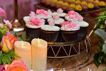 candles decorating candy table ,cupcake with pink flowers, cupcakes with pink roses, chocolate cupcake, flower cupcake, candy table, birthday cupcakes, party candy, flower decorated candy