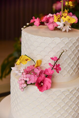 birthday cake, white cake, fondant cake, closeup on flowers on birthday cake, dark blurred background
