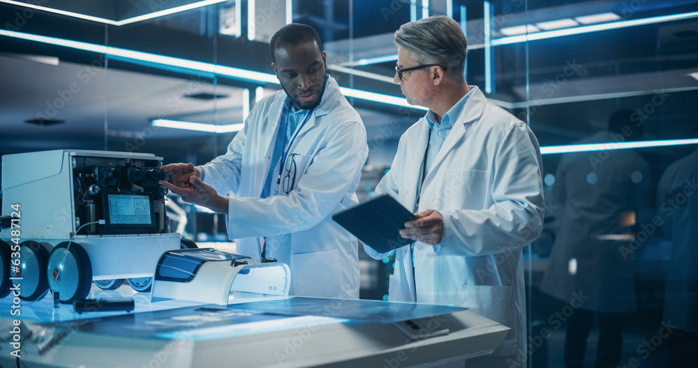 Poster Portrait of Two Diverse Male Industrial Robotics Specialists Working on a Mobile Robot. Caucasian And Black Engineers In Lab Coats Discussing an Automated Robotic Delivery Assistant with AI.
