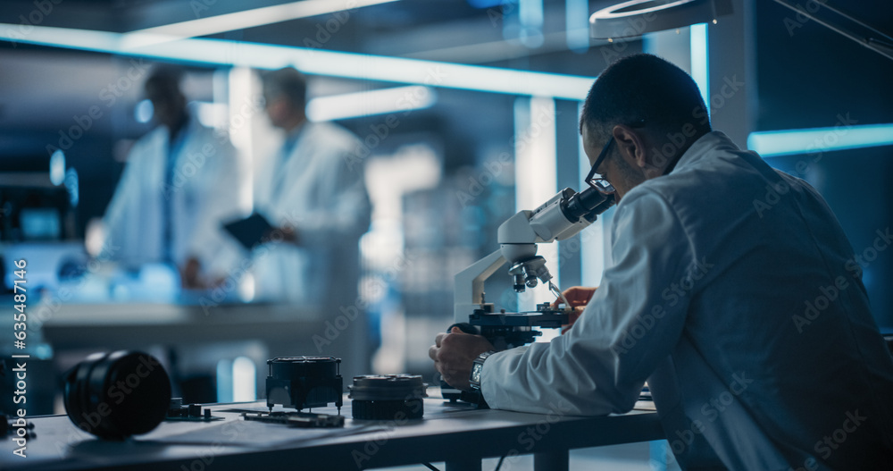 Aufkleber Scientist Using Modern Digital Microscope in a Research and Development Facility. On Blurred Background Diverse Team of Industrial Specialists Working on Remotely Controlled Mobility Robot