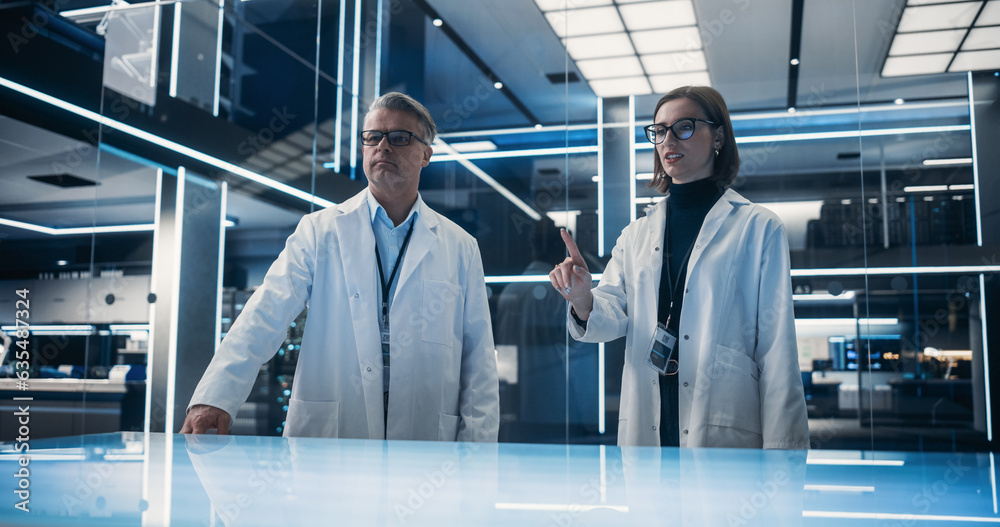 Leinwandbilder caucasian male and female scientist standing in the high tech laboratory next to the table. professi