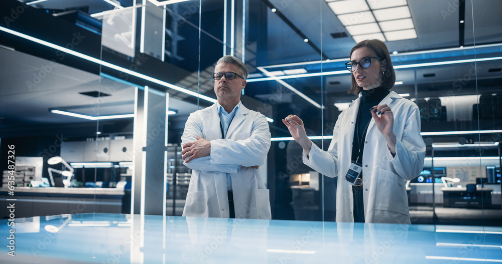 Leinwandbilder caucasian male and female scientists standing in the high-tech laboratory next to the table. profess