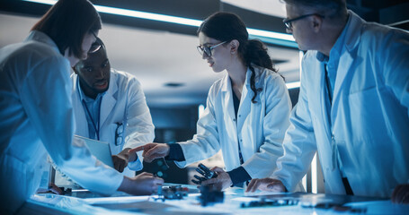 Portrait of a Group of Industrial Robotics Engineers Working on Humanoid Robot, Consulting with Specialists, Analyzing Electronic Components. Female Scientist Having a Meeting with Her Team.