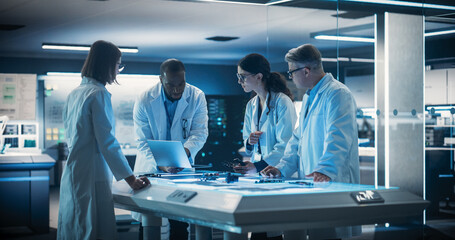 Portrait of Group of Industrial Robotics Engineers Working on a Humanoid Robot, Consulting with...