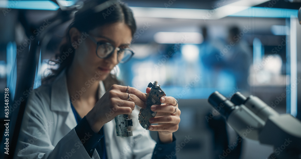 Poster Focused Professional Female Engineer Working on Electronic Circuit Boards. Industrial Robotics Specialists in Lab Coats Developing Mobile AI Robot in an Advanced Technology Factory Facility.