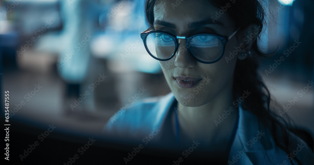 Poster portrait of beautiful multiethnic woman working on computer with the screen reflecting in her glasse