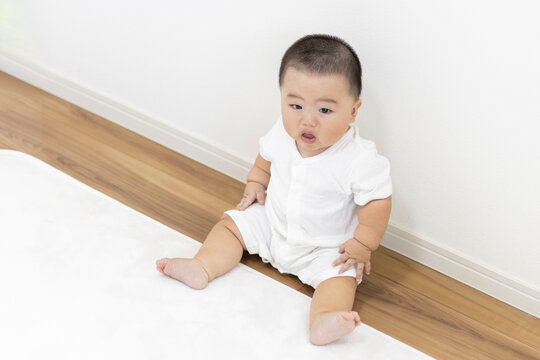 絨毯に座って泣く赤ちゃん（男の子、日本人、生後8か月）