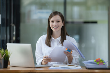 A businesswoman and accountant read reports for information, financial data, or analysis....