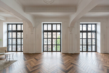 a chic expensive bright interior of a huge living room in a historic mansion with arched arches, columns and white walls decorated with ornaments and stucco.