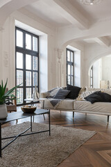 a chic expensive bright interior of a huge living room in a historic mansion with arched arches, columns and white walls decorated with ornaments and stucco.