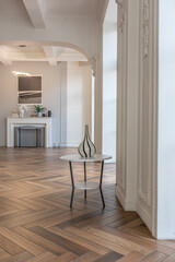 a chic expensive bright interior of a huge living room in a historic mansion with arched arches, columns and white walls decorated with ornaments and stucco.