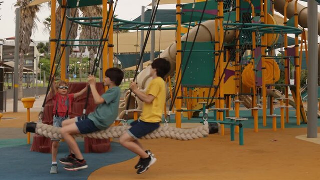 Happy children, boys, playing on playground in Tel Aviv, israel on a hot summer day