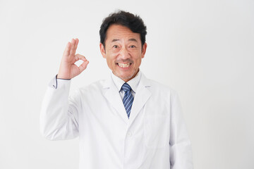 OKポーズをするミドルエイジの医者　白背景