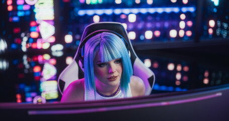 Portrait of a Stylish Streamer and Video Gamer with Blue Hair Chats with Internet Fans on Computer in Futuristic Cyber Technology Room. Footage for Social Media, Streaming, and Gaming Content