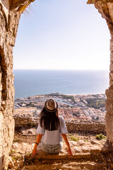 Young tourist woman and sea landscape with Terracina, Lazio, Italy. Scenic resort town village with nice sand beach and clear blue water. Famous tourist destination in Riviera de Ulisse