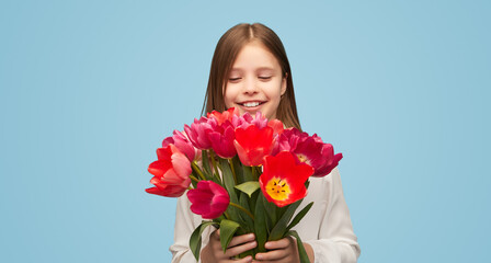 Little girl with colorful tulips on blue background