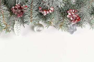 Christmas card with fir branches, viburnum berries covered with hoarfrost, and Christmas...