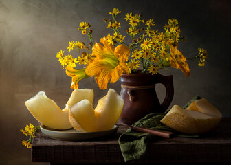 Still life with melon and yellow flowers in an earthenware jug © 02irina