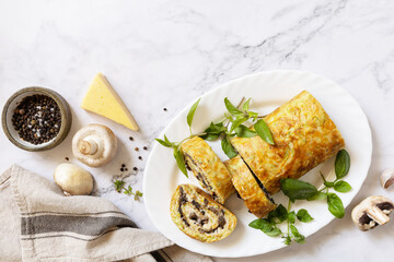 Vegetarian delicious food. Zucchini roll (roulade) with cheese and mushrooms on a marble tabletop. View from above.