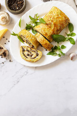 Vegetarian delicious food. Zucchini roll (roulade) with cheese and mushrooms on a marble tabletop. View from above. Copy space.