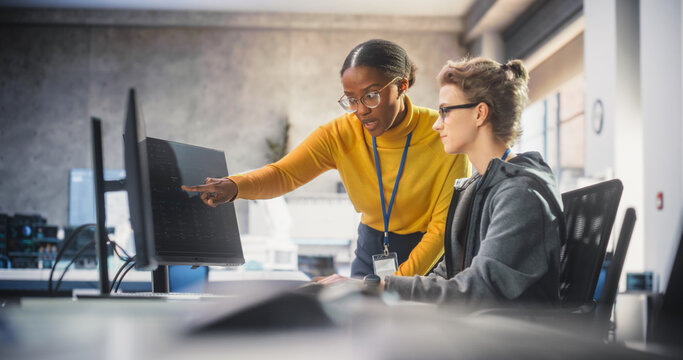 Diverse Young Female Students Working Together in Infographics Room, Collaborating on a College Research Project. Young Scholars Talking, Study Software Development or Computer Science