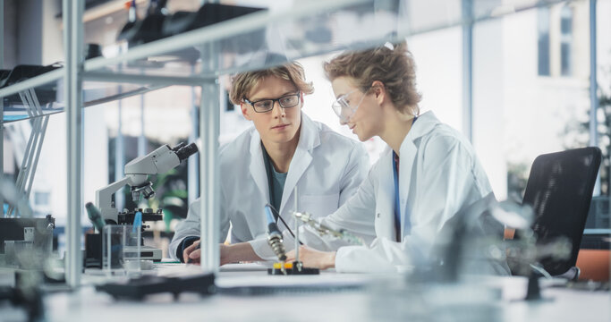 Young Female and Male Students Working Together in Laboratory Classroom, Collaborating on a College Research Project. Young Scholars Talking, Study Electronics or Science Engineering