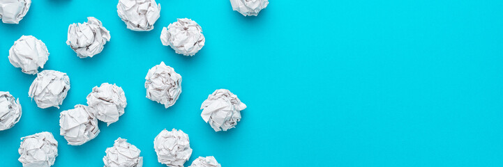 Top view photo of crumpled white paper on turquoise blue background. Flat lay top-down composition of brainstorming concept with copy space.