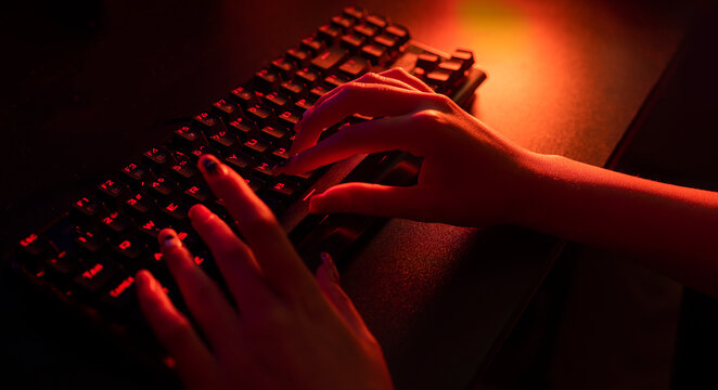 Female hand typing on the black keyboard