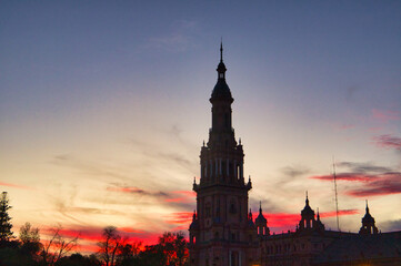 Fototapeta premium Night view of the monument of plaza de spain in seville, spain. Reddish sky at sunset in the city.