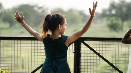 Portrait of beautiful little indian teenager girl stand cross arms while standing in the park...