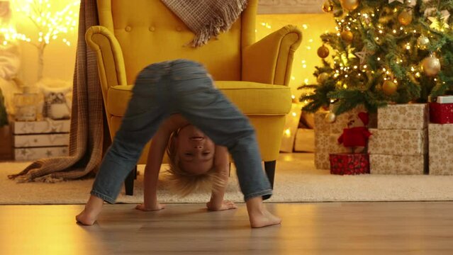 Cute child, boy, playin in front of yellow armchair in a decorated room for Christmas, cozy place