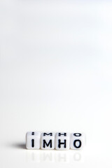 imho word or concept made by white letter cubes on white and gray background, in my honest humble...