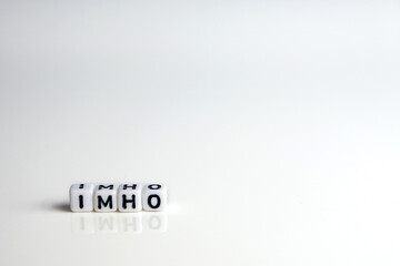 imho word or concept made by white letter cubes on white and gray background, in my honest humble...