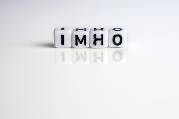 imho word or concept made by white letter cubes on white and gray background, in my honest humble...