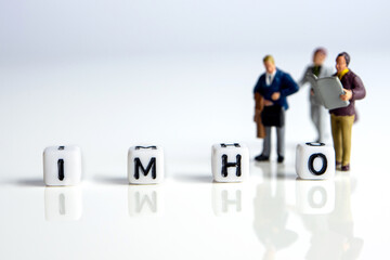 imho word or concept made by white letter cubes on white and gray background with miniature...