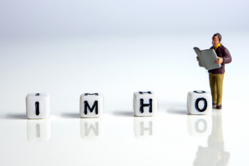 imho word or concept made by white letter cubes on white and gray background with miniature...