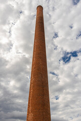 Old factory chimney, with cloudy sky in the background