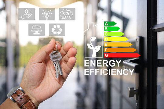 Businessman holding home's key or purchase modern house design and built to compile governance energy label efficiency requirement certified which saves energy and environment reduce CO2 emission.
