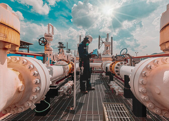 Male worker inspection at steel long pipes and pipe elbow in station oil factory during refinery...