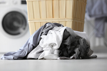 Stack of dirty clothes on floor in laundry room, closeup