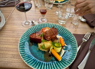 Gastronomic Delight: Colorful Pork Meal at a Restaurant, Served on a Blue Plate with Wine
