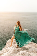 Woman sea trevel green dress. Side view a happy woman with long hair in a long mint dress posing on a beach with calm sea bokeh lights on sunny day. Girl on the nature on blue sky background.
